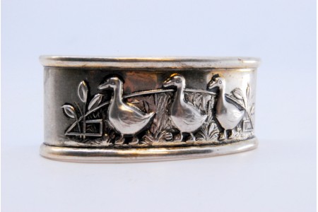 Argola de guardanapo em prata em forma oval três patos relevados.